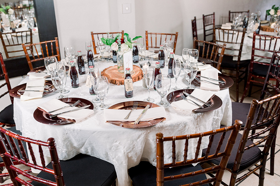  wooden table with white linens and wooden chairs