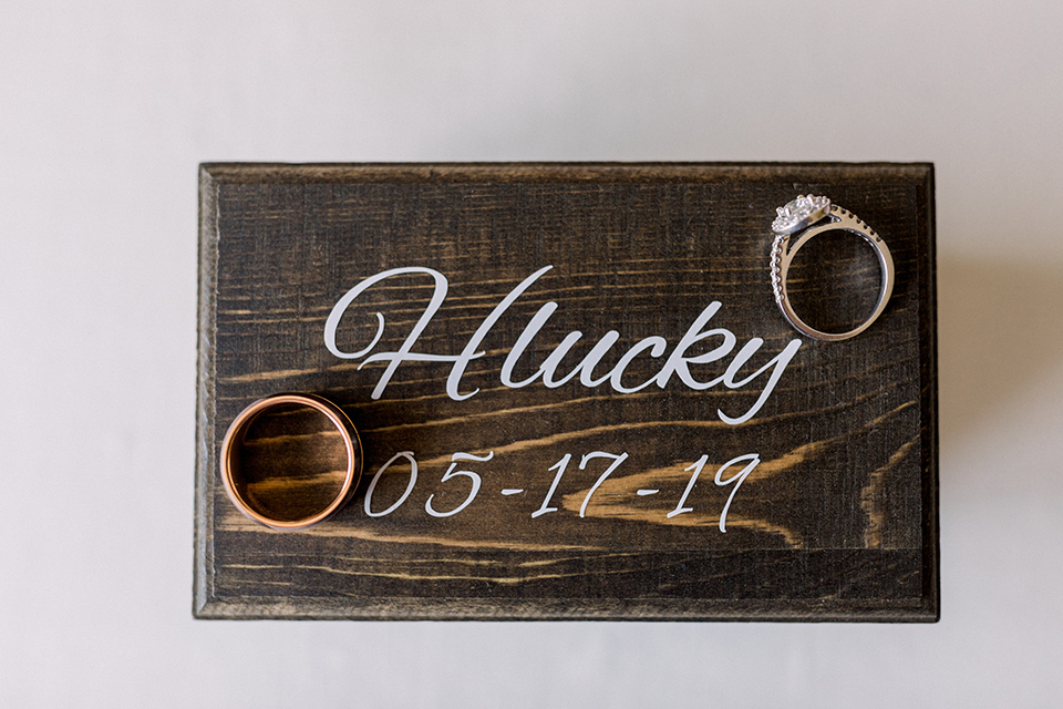  rings on a wooden box with the couple’s last name