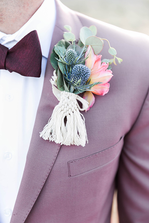  groom in a rose pink suit with a burgundy bow tie