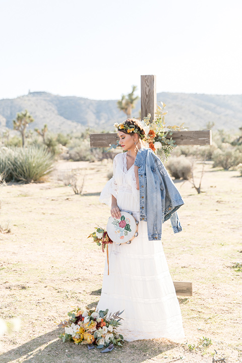  bride in a bohemian style gown with lace and a floral crown and a jean jacket