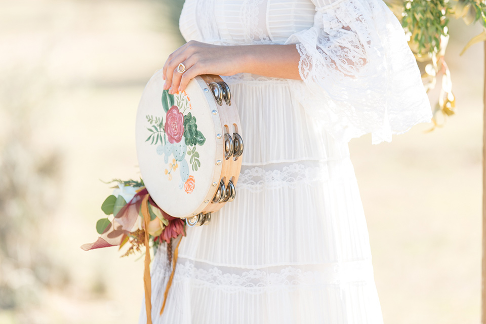  bride in a lace bohemian gown with a tambourine 