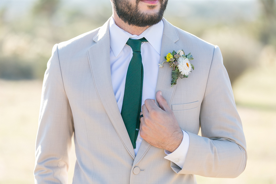  groom in a tan notch lapel suit with a teal blue long tie