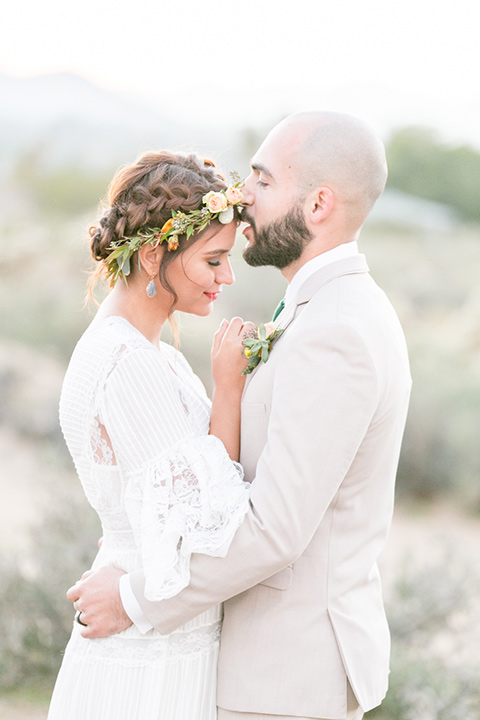  bride in a bohemian style gown with lace and a floral crown and a jean jacket