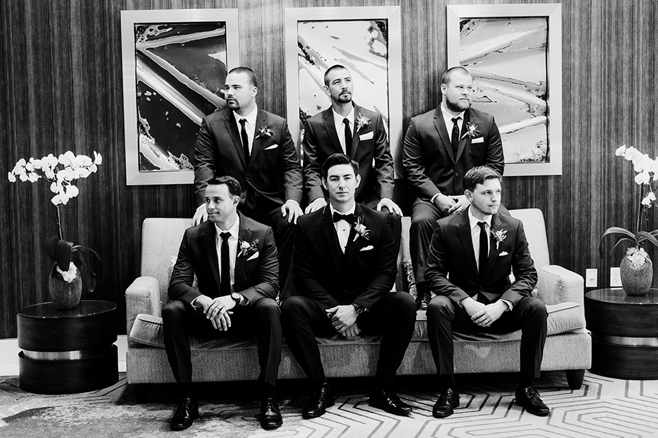  groom and groomsmen in black tuxedos with black bow ties