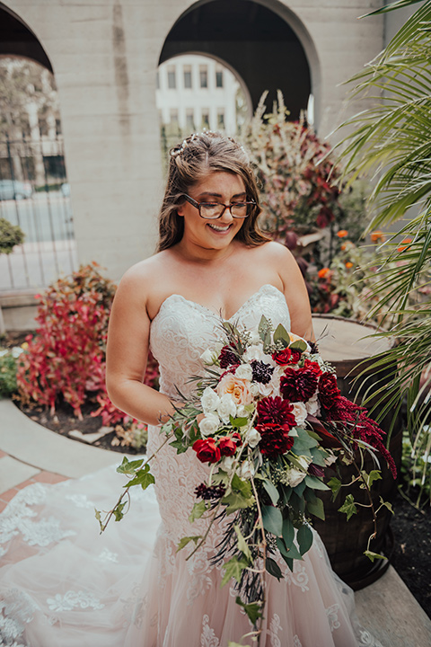  bride in a formfitting white lace gown with a long train 