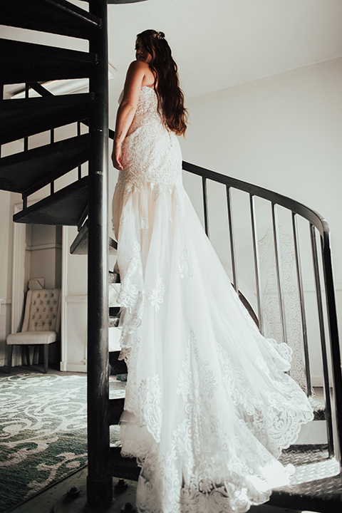  bride in a formfitting white lace gown with a long train