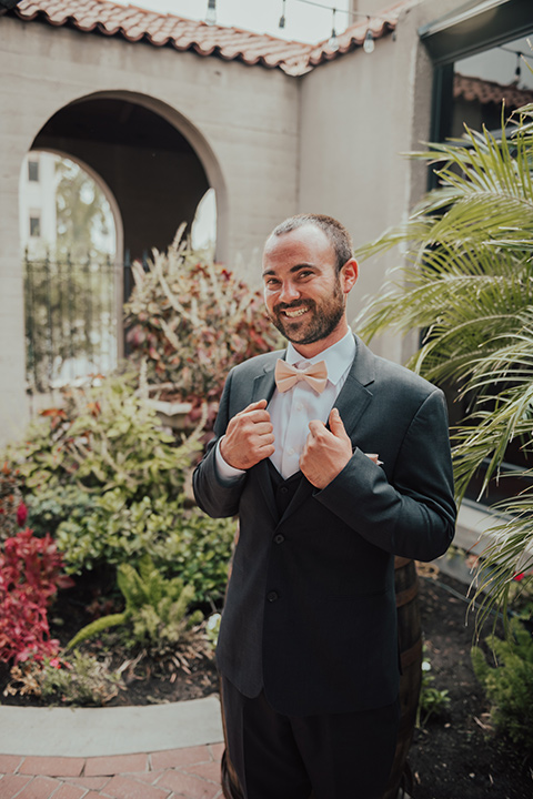  bride in a formfitting white lace gown with a long train and the groom in a dark blue suit