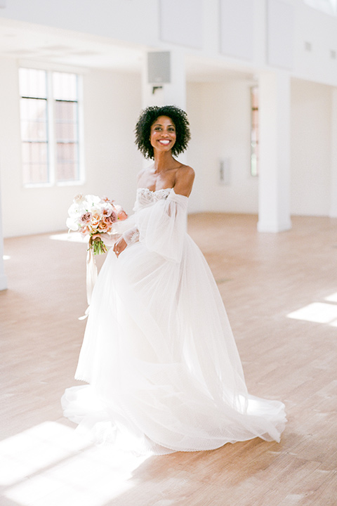  bride in a tulle ballgown with an off the shoulder detail and full billowed sleeves