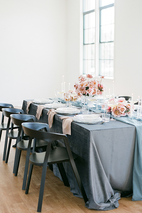   dusty blue linens with tall candles and blush toned florals 