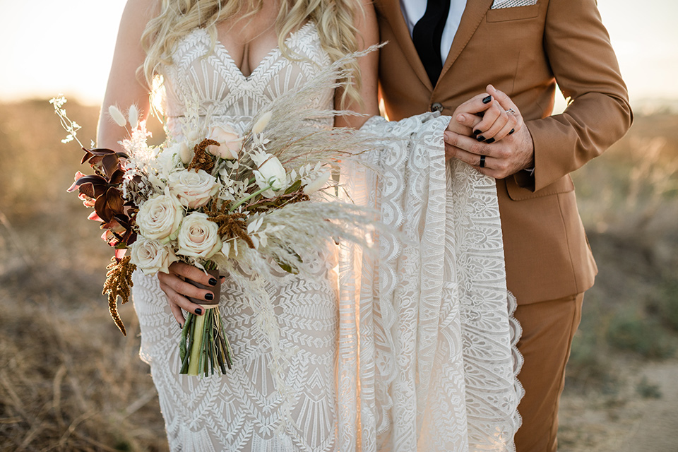 bride in a lace bohemian gown and the groom in a caramel brown suit with a chocolate brown long tie and fun pocket square 