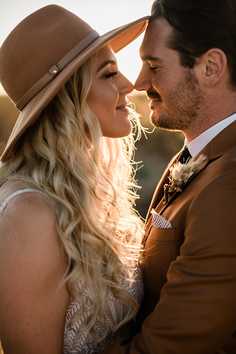  bride in a lace bohemian gown and the groom in a caramel brown suit with a chocolate brown long tie and fun pocket square 