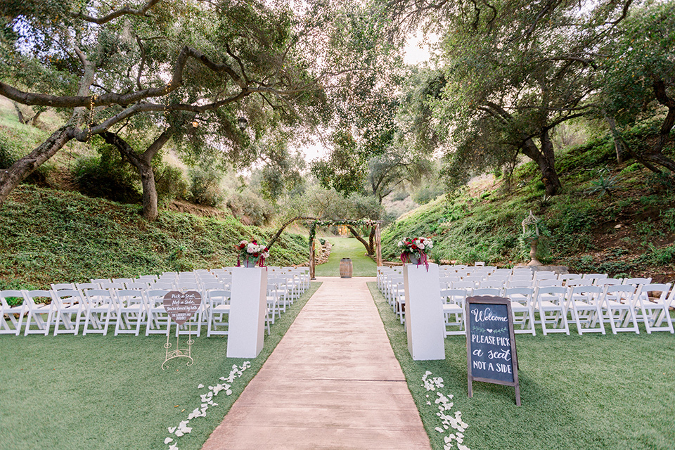  bride in a mermaid style lace white gown and the groom in a light grey suit with a light brown shoes and white pocket square, the bridesmaids in sage green dresses and the groomsmen in light grey suits and bow ties