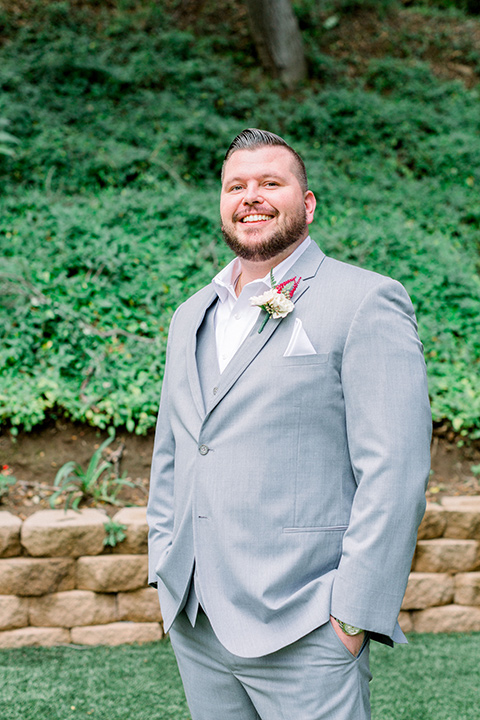  groom in a light grey suit on a tree swing