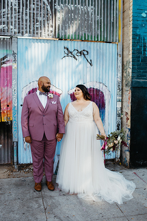  bride in a tulle ballgown with cap sleeves and the groom in a rose pink suit 