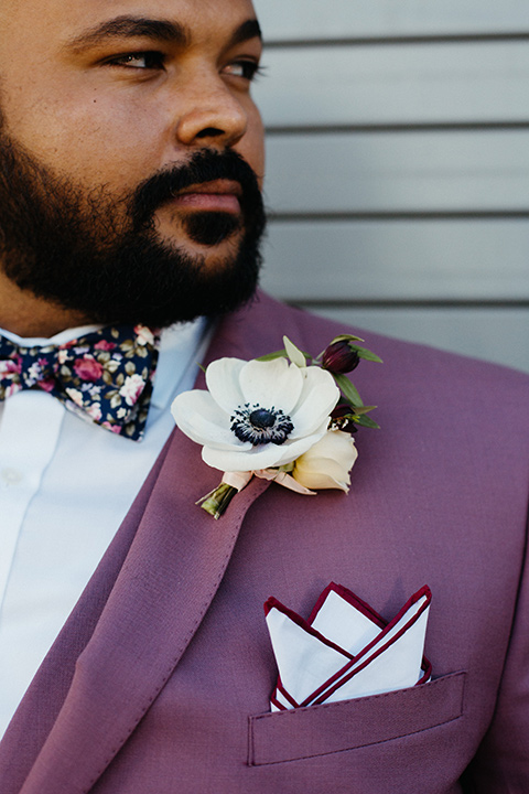  groom in a rose suit with a floral bow tie