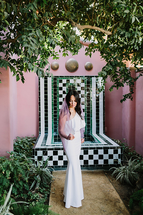  bride in a white bohemian gown with one sleeve and a ruffled detail