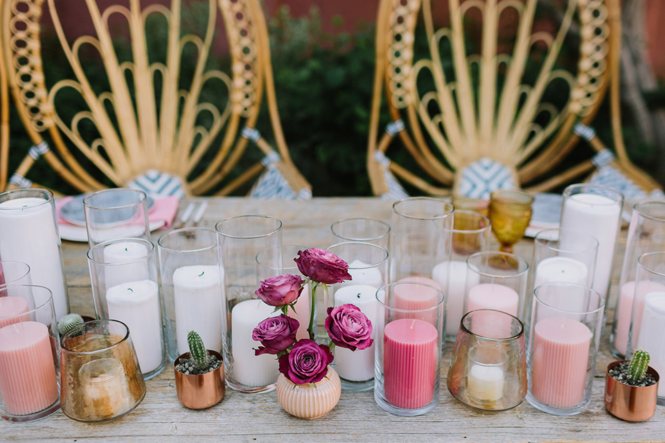  wooden bohemian chairs at the sweetheart table with short and tall candles in many different fun colors