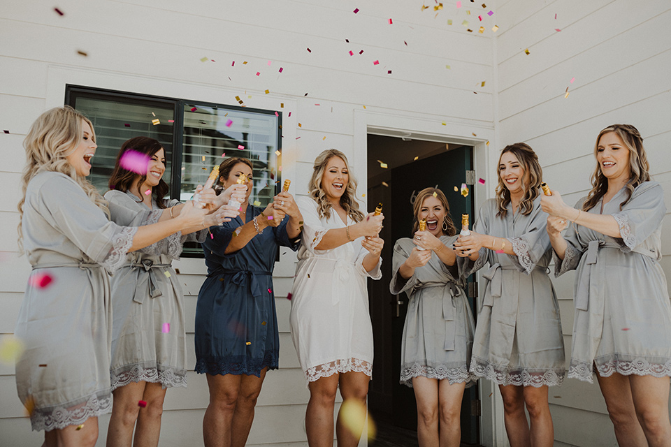  =” bride an bridesmaids in robes with champagne