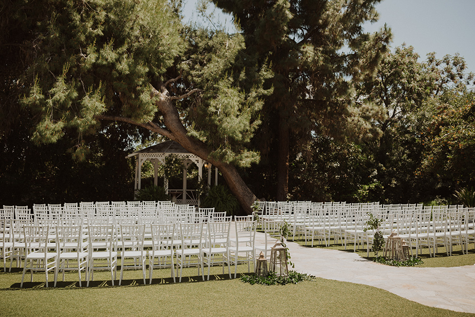  =” white chairs for the ceremony over looking tall trees and white flowers