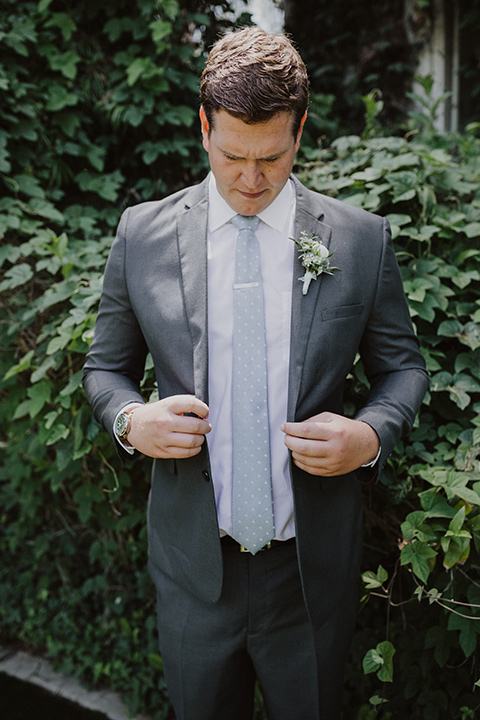  the groom in an asphalt grey suit by Michael Kors with a light blue patterned long tie 