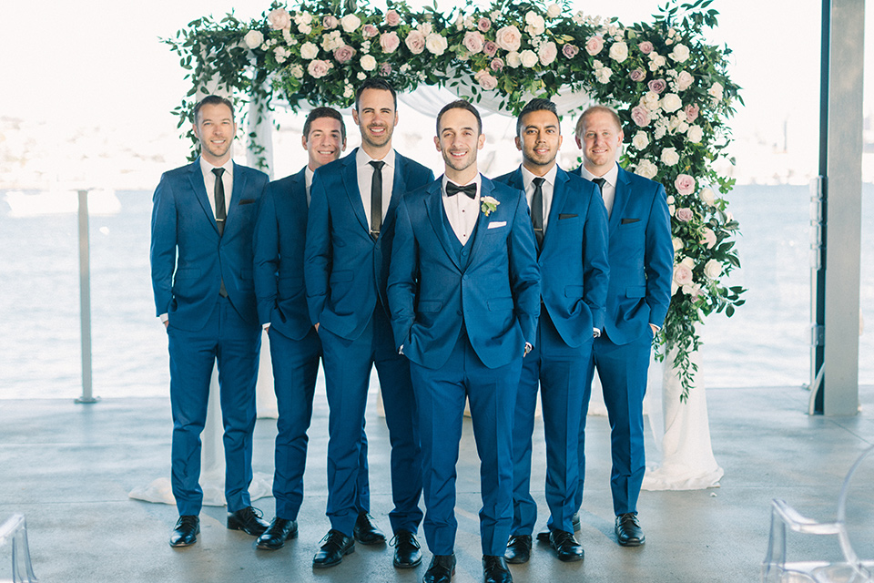  groom and groomsmen in cobalt blue suits with black bow and long ties