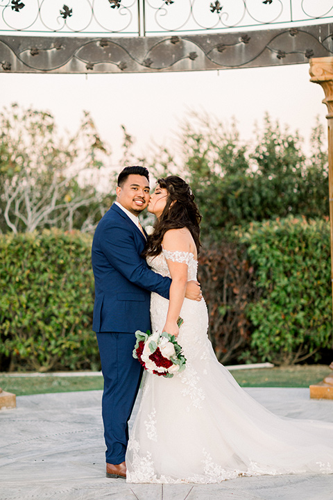  bride in a Spanish style lace gown and the groom in a cobalt blue suit with a pink suit 