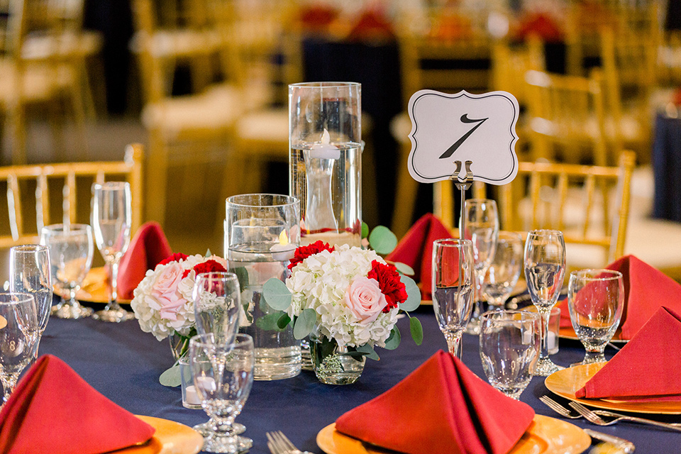  blue table linens with red napkins with gold flatware