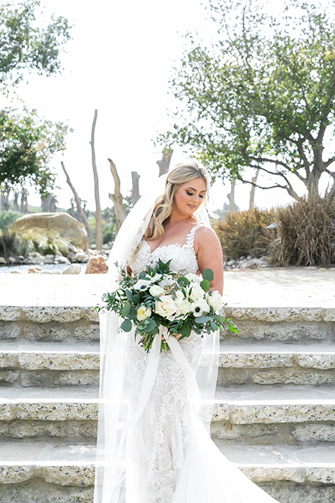  bride in a white lace gown and long veil