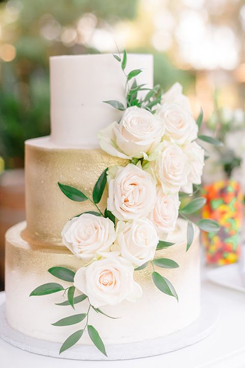  white and gold cake with white florals flowers