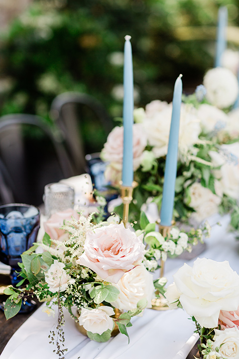  table décor with white linens and tall blue candles 