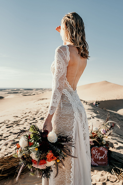  bride in a lace gown with long sleeves and a wide brimmed hat 