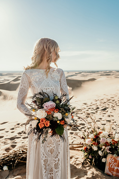  bride in a lace gown with long sleeves and a wide brimmed hat 