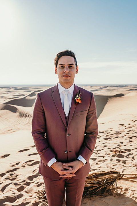  groom in a rose pink suit with a white long tie