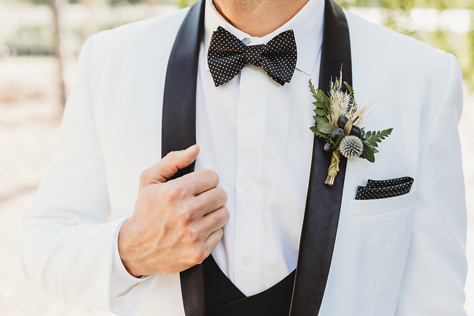  groom in a white with a black shawl lapel tuxedo