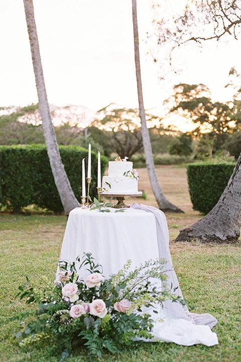  bride in a white formfitting gown with a long ethereal cape and her hair in a low bun