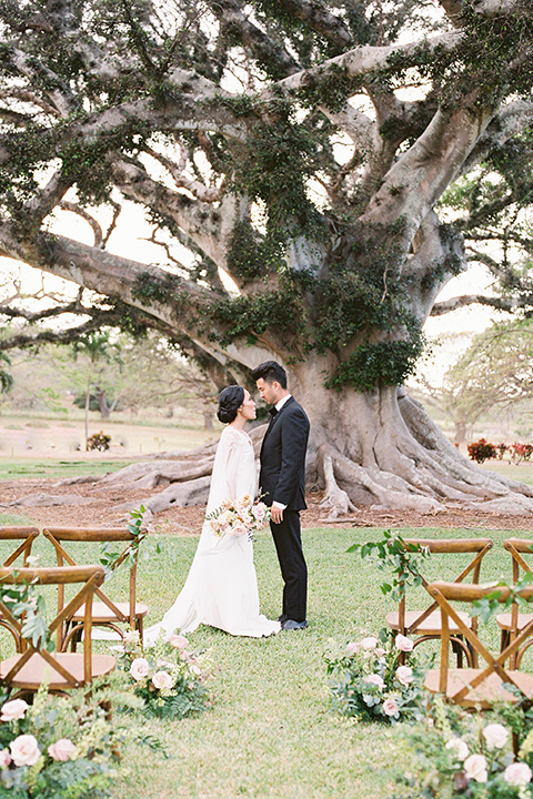  and the groom in a black notch lapel tuxedo with bow tie at ceremony 