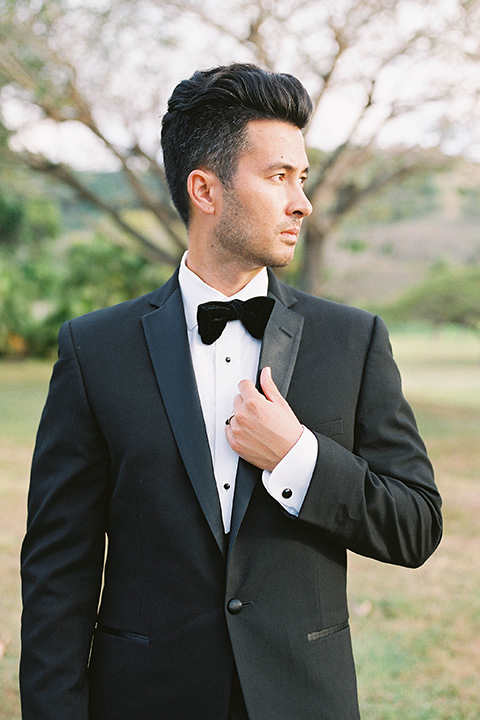  the groom in a black notch lapel tuxedo with bow tie 