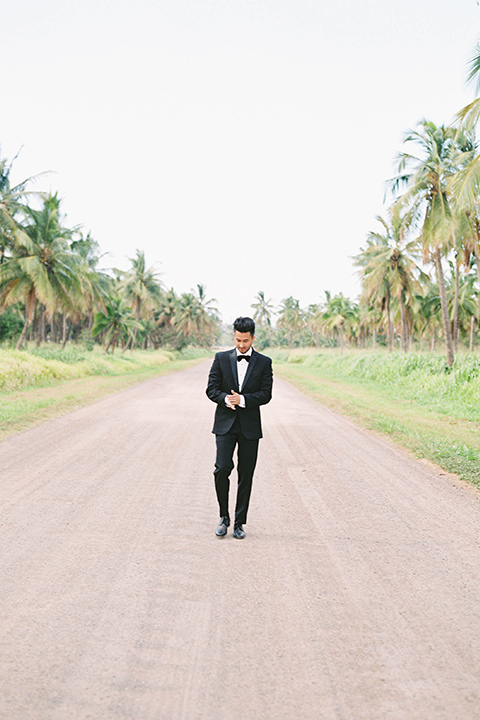  the groom in a black notch lapel tuxedo with bow tie 