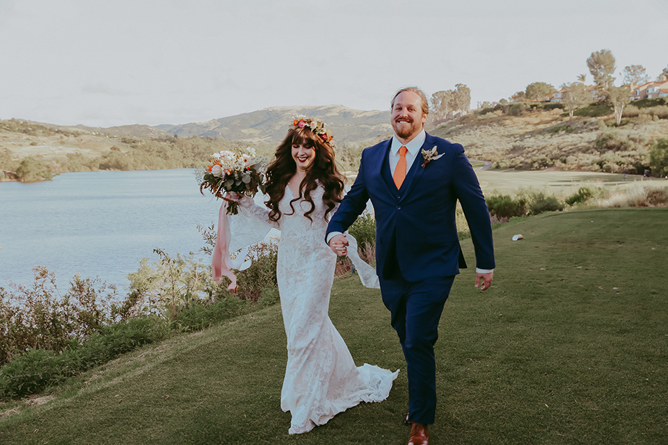  bride in a lace bohemian gown with tulip sleeves and a braided crown, the groom in a cobalt blue suit for purchase 