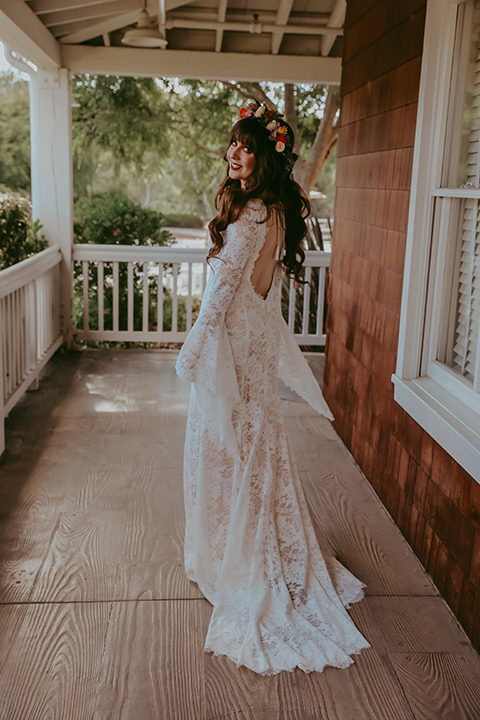  bride in a lace bohemian gown with tulip sleeves and a braided crown 