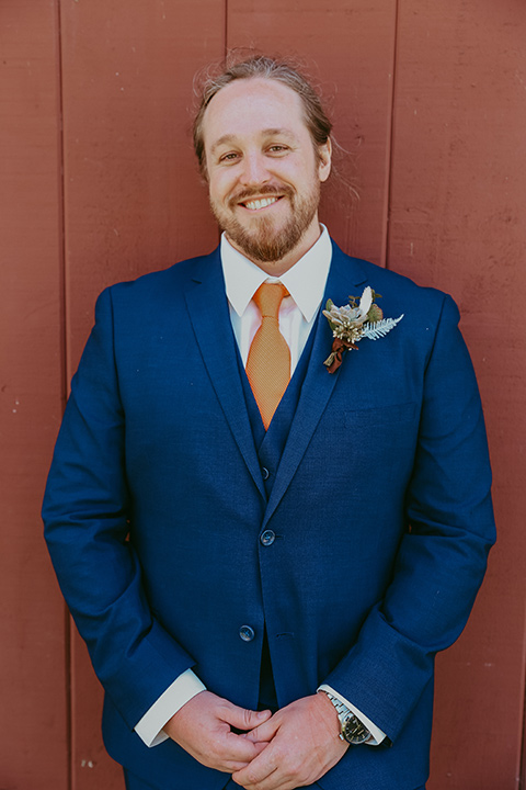  the groom in a cobalt blue suit for purchase with a burnt orange tie 