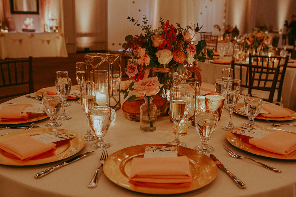  white table linens with burnt orange napkins and gold flatware