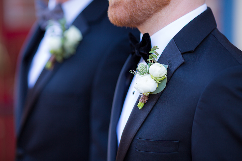 grooms in black tuxedos with white shirts and black bow ties