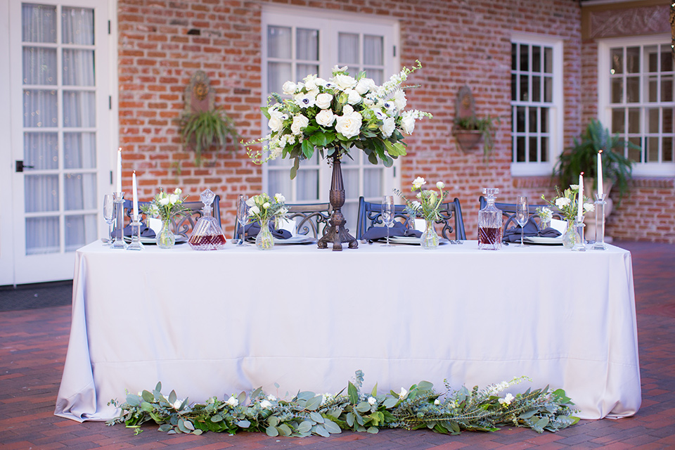 white table linens with tall white rose centerpieces