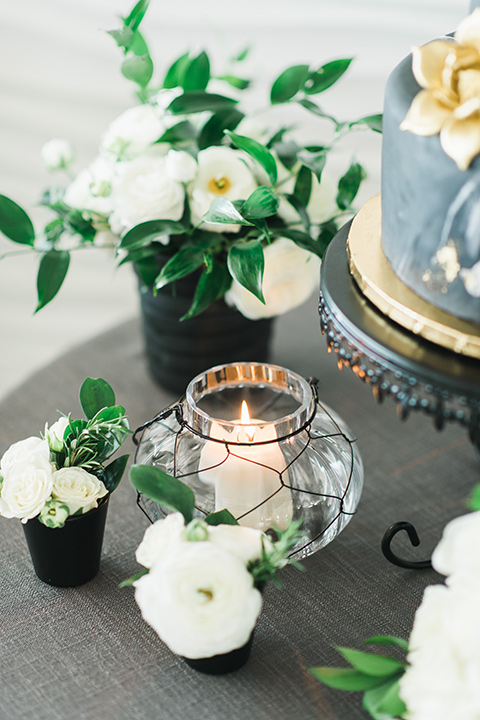 gold candle holders with black vases and white wedding florals