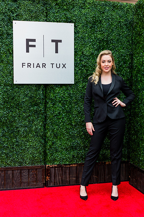  model in a black tuxedo with a black bralette on and high heels 