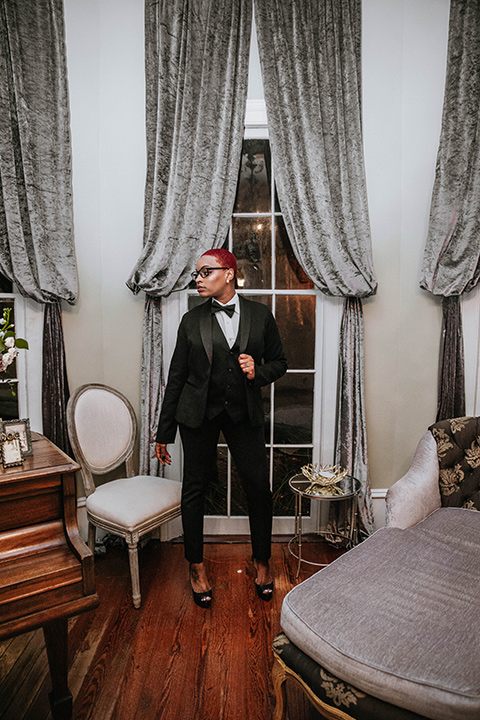  sister in a wedding wearing a tuxedo and heels and standing on her brother’s side 