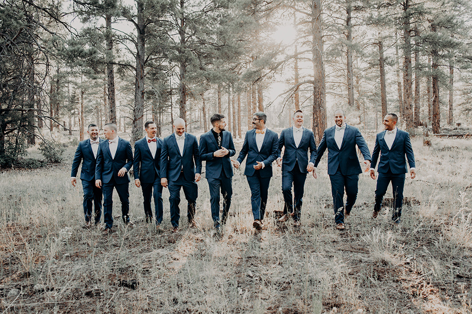  groom and groomsmen in dark blue suits with bow ties 