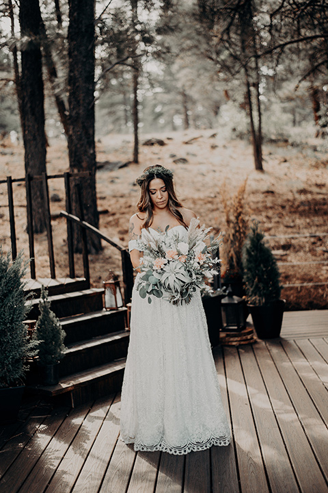  bride in a bohemian gown with an off the shoulder detail and a floral crown