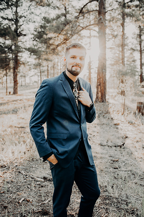  the groom in a blue suit with bow tie